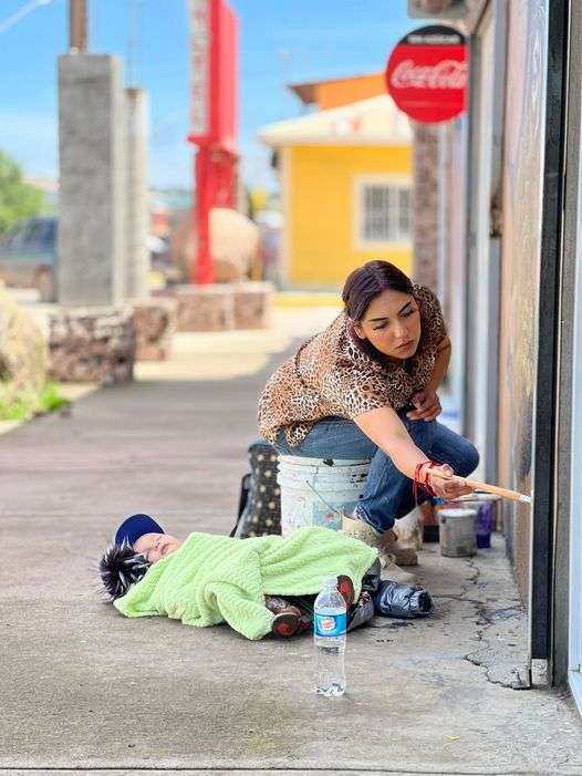 Captan a una artista urbana trabajando con su bebé al aire libre