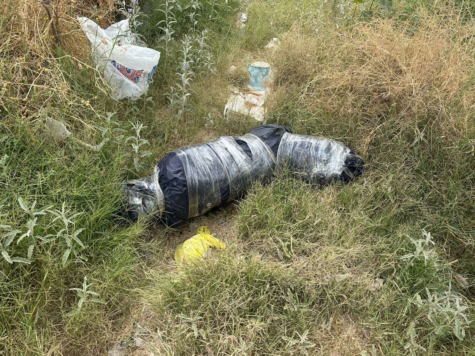 Arrojan cadáver envuelto en una lona a un arroyo
