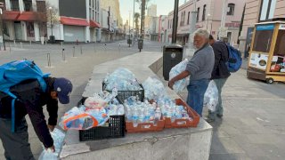 Recogen personas en situación de calle botellas de agua abandonadas